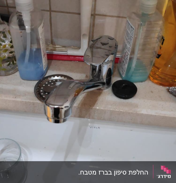 ברז נירוסטה מעל כיור עם סבון כלים